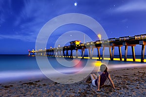 Woman sitting on shore at night photo