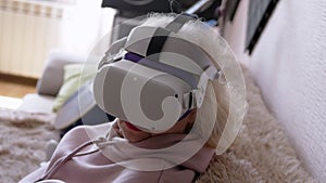 Woman Sitting on Sofa in Helmet with 3D Virtual Reality Glasses. 4K. Close up