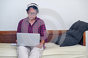 Woman sitting on sofa with her computer on her lap working from home