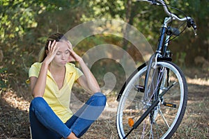 Woman sitting on soil next to bike