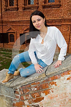 Woman sitting on stone staircase railing