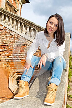 Woman sitting on stone staircase railing