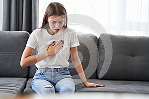 Woman sitting with strong chest pain