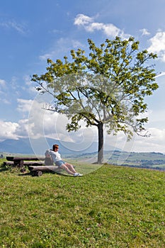 Woman sitting on summer hill near Liptovsky Trnovec, Slovakia.