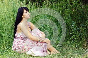 Woman sitting on the summer meadow