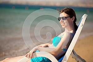 Woman sitting on sun deckchair