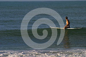 Woman Sitting on Surfboard
