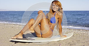 Woman Sitting on Surfing Board at the Beach