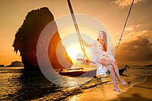 Woman sitting on a swing on the beach  in Krabi, Thailand