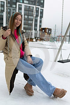 Woman Sitting on Swing in Snow