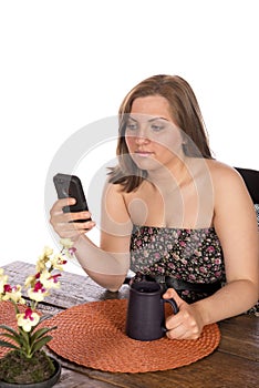 Woman sitting at table on cell phone