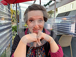 A woman is sitting at a table with a scarf around her neck