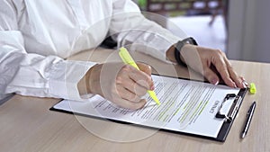 Woman sitting on table underline words in fold office in the contract. Business woman stressing with green marker important things