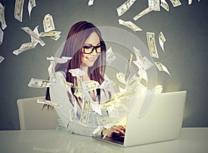 Woman sitting at table using working on a laptop computer making money