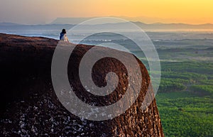 Woman sitting on the three whale rock mountain at Bueng Kan Province,Thailand