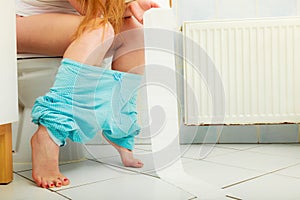 Woman sitting on toilet in morning