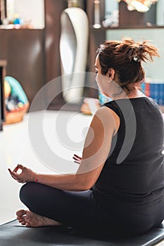 a woman sitting on top of a yoga mat while meditating