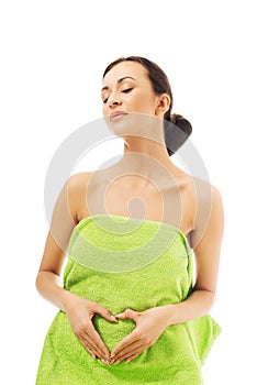 Woman sitting in towel, making heart shape