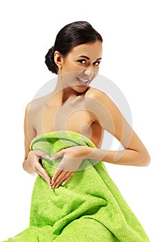 Woman sitting in towel, making heart shape