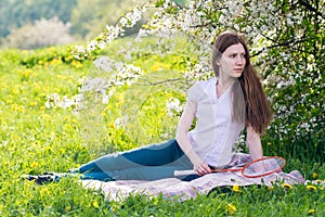 Woman sitting under blossom tree