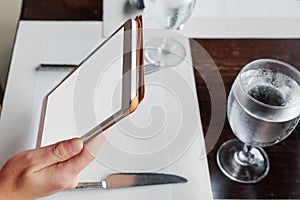 Woman sitting using a tablet on dining table in restaurant