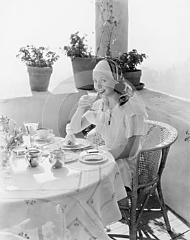 Woman sitting on a verandah having breakfast