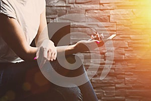 Woman sitting at the wall and browsing the phone.