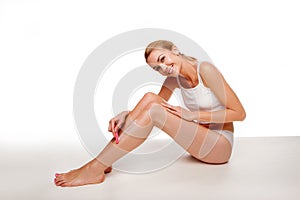 Woman sitting waxing her legs