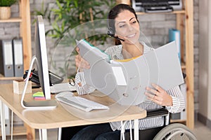 woman sitting in wheelchair working in modern office