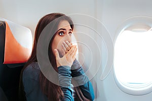 Woman Sitting By the Window on An Airplane Feeling Sick