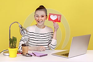 Woman sitting at workplace with laptop, asking to rate her posts showing likes counter template.