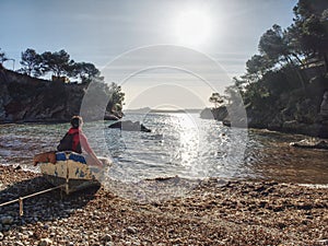 Woman sitting in wrecked boat and enjoy sunbathing.