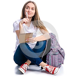 Woman sitting writing in notebook with pen backpack