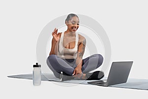 Woman Sitting on Yoga Mat With Laptop