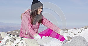 Woman with skateboard on mountain peak