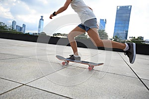 Woman skateboarder riding skateboard at city