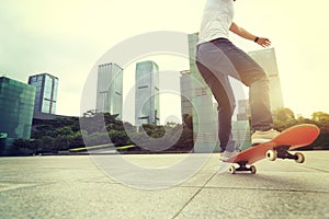 Woman skateboarder riding skateboard on city