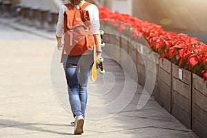 Woman skateboarder walking with skateboard