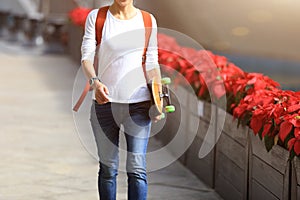 Woman skateboarder walking with skateboard