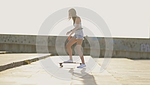 A woman is skateboarding on a sidewalk
