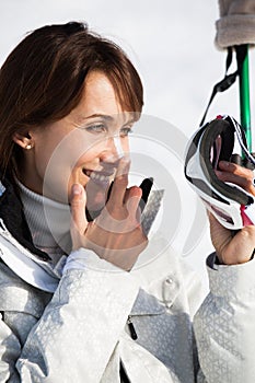 Woman on the ski slopes applying a protective cream