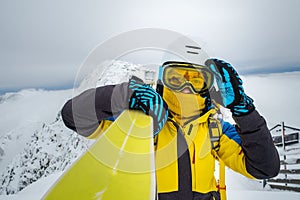 woman skier posing on the top of snowed mountain