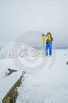 woman skier posing on the top of snowed mountain