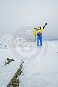 woman skier posing on the top of snowed mountain