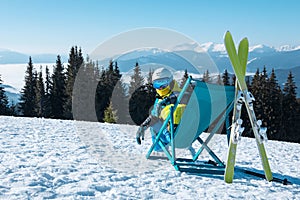 woman skier sitting in the chair with beautiful mountains panoramic view