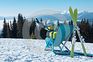 woman skier sitting in the chair with beautiful mountains panoramic view