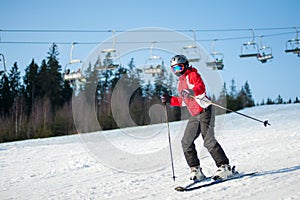 Woman skier with ski at winer resort in sunny day