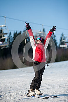 Woman skier with ski at winer resort in sunny day