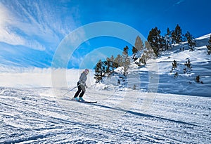 Woman skiing down the ski slope in Pyrenees Mountains, Andorra