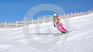 Woman skiing at Sinaia resort in Romania on a sunny day with perfect snow, on a medium difficulty slope red piste.